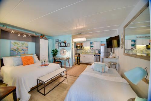 1 dormitorio con 2 camas y cocina en Chic Virginia Beach Retreat - Pool, Steps to Beach en Virginia Beach