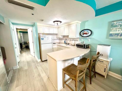 a kitchen with a white refrigerator and a counter at Daytona Beach Resort Oceanfront 1 Bedroom Suite, 2 Queen Beds in Daytona Beach