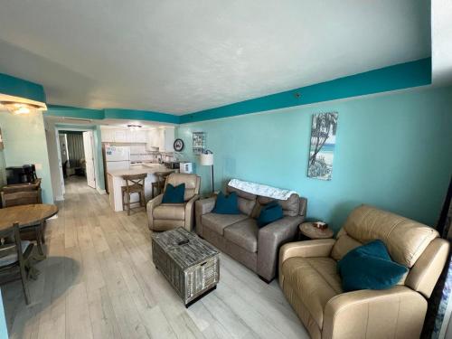 a living room with blue walls and couches and a table at Daytona Beach Resort Oceanfront 1 Bedroom Suite, 2 Queen Beds in Daytona Beach