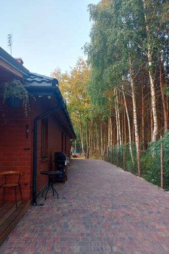 a brick walkway next to a building with trees at Dom imprezowy z noclegami Dziecinów in Dziecinów