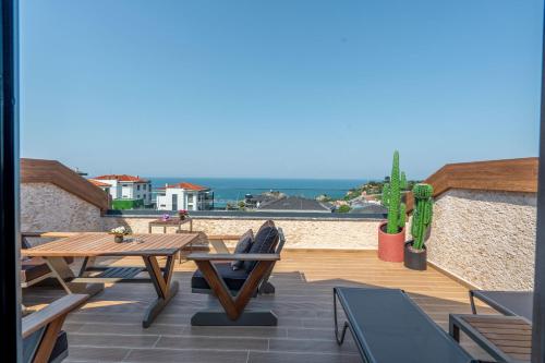 um pátio com uma mesa e cadeiras e o oceano em La Miel Suites em Şile