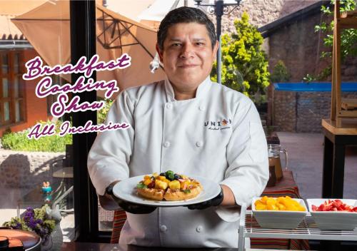 een chef-kok houdt een bord eten vast bij Union Hotel Cusco in Cuzco