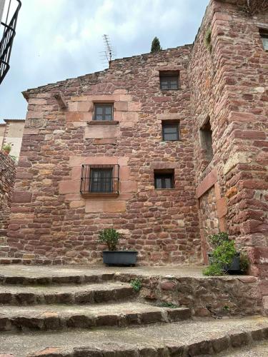 a brick building with stairs in front of it at Casa Castillo in Vilafamés