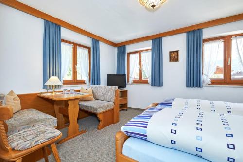 1 dormitorio con cama, silla y escritorio en Landhaus Lengg, en Reit im Winkl