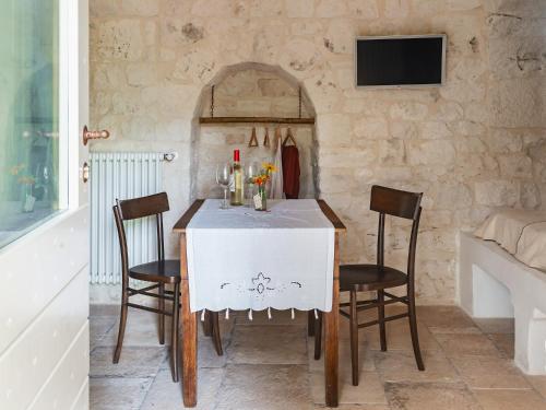 a dining room with a white table and chairs at Trulli Del Bosco in Alberobello