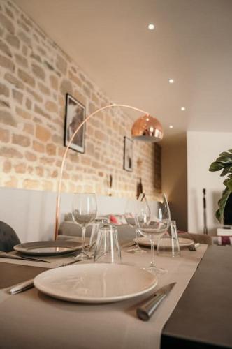 une table avec des assiettes et des verres à vin dessus dans l'établissement Le Grand Arches, à Charleville-Mézières