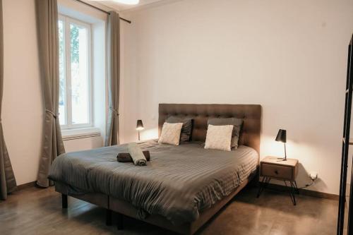 a bedroom with a large bed and a window at Le Grand Arches in Charleville-Mézières