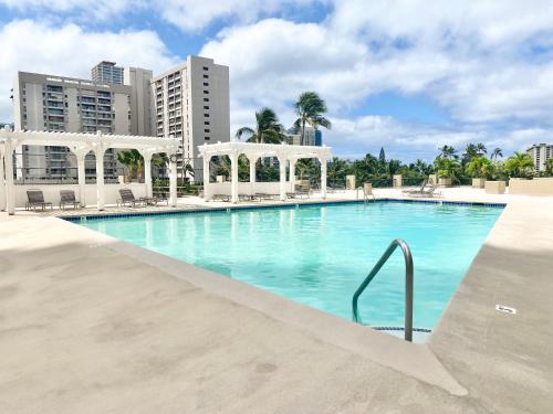 ein großer Pool mit Gebäuden im Hintergrund in der Unterkunft Hawaiian monarch cozy studio in Honolulu