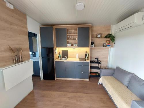 Il comprend un petit salon avec un canapé et une cuisine. dans l'établissement Casa Malu - mobile house by the Kolpa river, à Metlika