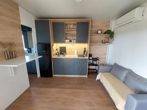 Il comprend un petit salon avec un canapé et une cuisine. dans l'établissement Casa Malu - mobile house by the Kolpa river, à Metlika