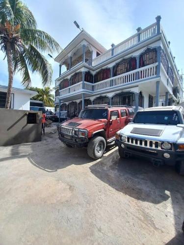 海地角的住宿－KING vacation Home，停在大楼前的两辆卡车