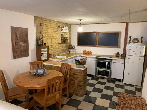 La cuisine est équipée d'une table, d'un évier et d'un réfrigérateur. dans l'établissement Appartement cosy Trouville, Plage & centre à pied, à Trouville-sur-Mer