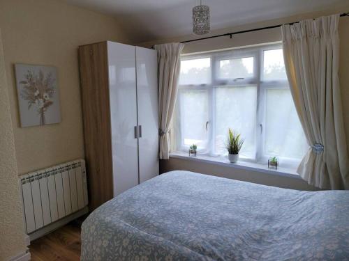 a bedroom with a bed and a large window at Rest & Relax Apartment in Tilehurst