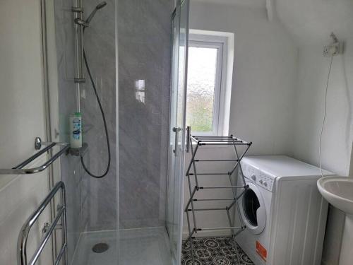 a bathroom with a shower and a washing machine at Rest & Relax Apartment in Tilehurst