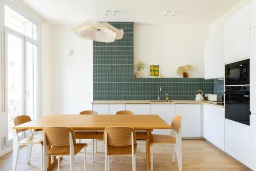 une cuisine avec une table et des chaises en bois dans l'établissement 90m2 Design, Calme, Wifi, Clim, Netflix, à Marseille