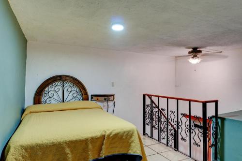 a bedroom with a bed with a yellow bedspread at Hotel Spa Casa del Sol in Guanajuato