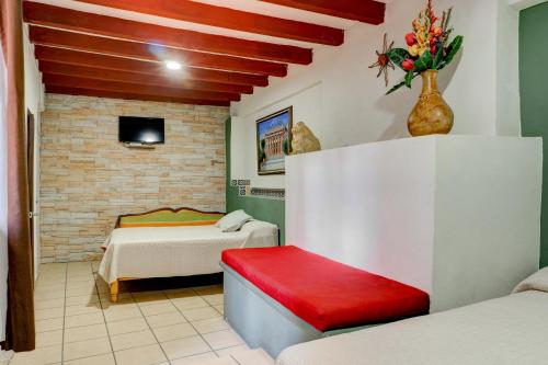 Habitación con 2 camas y un jarrón de flores en Hotel Spa Casa del Sol, en Guanajuato