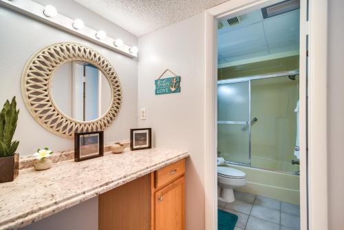 a bathroom with a sink and a toilet and a mirror at Balcony and Stunning Views Oceanfront Condo! in Clearwater Beach