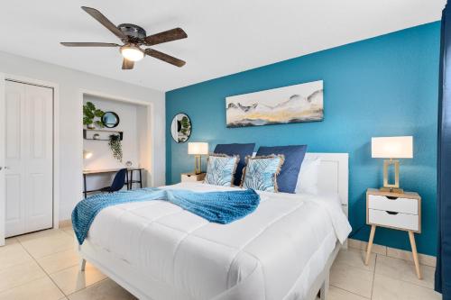 a blue bedroom with a bed and a ceiling fan at Ocean 3 - Deep Blue in Indian Harbour Beach
