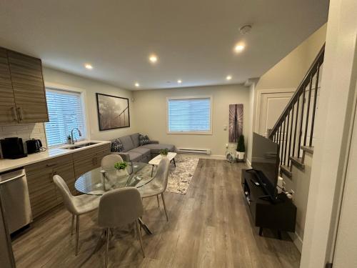 a kitchen and a living room with a table and chairs at Bright and cozy modern home in Vancouver - central to YVR-Downtown - Free Private Parking in Vancouver
