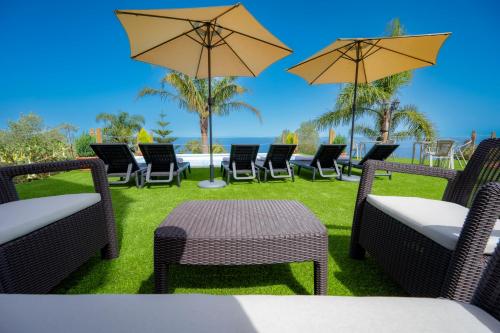 a group of chairs and tables with umbrellas at Finca El Pastel in Tacoronte