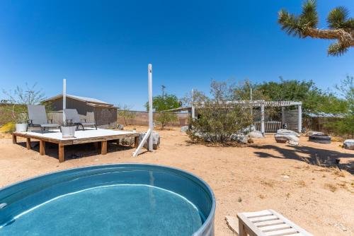 a swimming pool in a yard with a picnic table and a picnic table at Glamingo Cabin in Yucca Valley