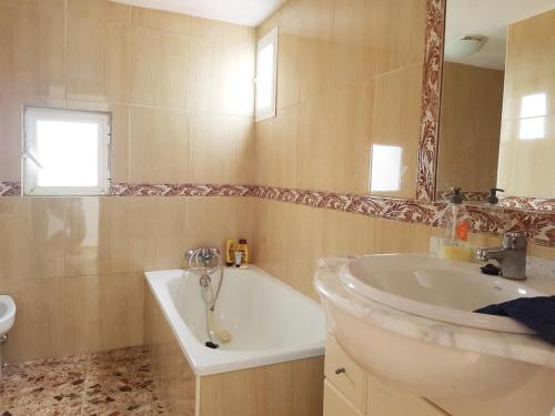 y baño con bañera, lavabo y espejo. en Quiet Getaway House in Alcala De Los Gazules, en Alcalá de los Gazules