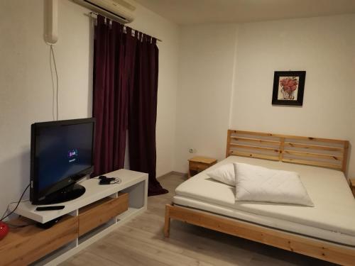 - une chambre avec un lit et une télévision sur une table dans l'établissement Studio D&D, à Vrh