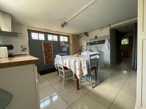 une cuisine avec une table et des chaises dans une cuisine dans l'établissement La Gaviota - gîte familial Le Bugue, au Bugue