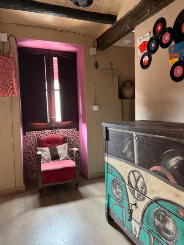 Habitación con cama, silla y discos en Ca la Traviesa - Refugio del Arte - Pet Lovers - Adults Only - Montsant en Bellaguarda