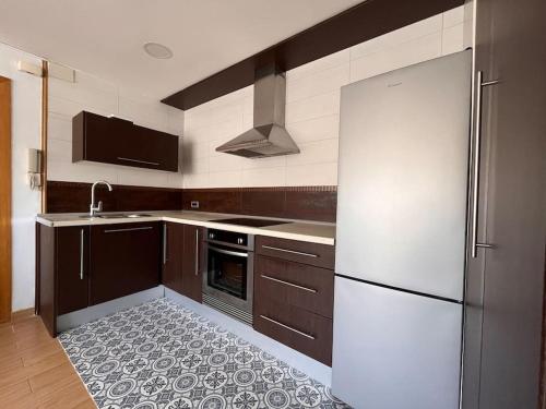 una cucina con frigorifero bianco e lavandino di Apartamento “La Caleta” a Calella