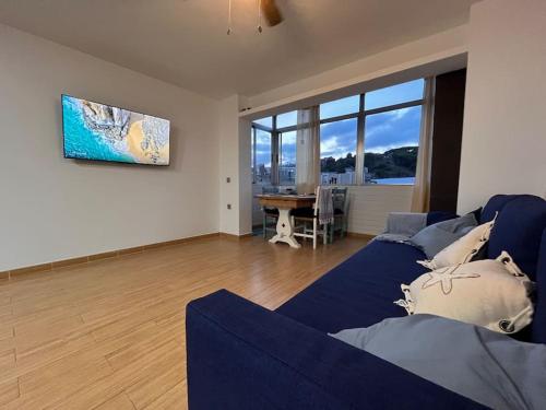 een woonkamer met een blauwe bank en een tafel bij Apartamento “La Caleta” in Calella