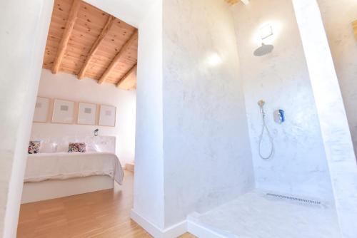 uma casa de banho com um chuveiro num quarto com uma cama em Casa Botijo by SIERRA VIVA desing em Linares de la Sierra