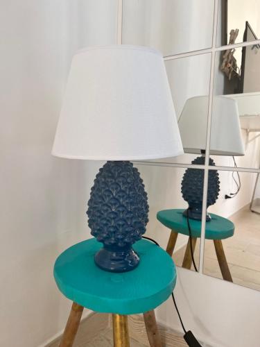 a lamp on a table with a green stool at Sea La Vie - Terrazza sul mare in Agropoli