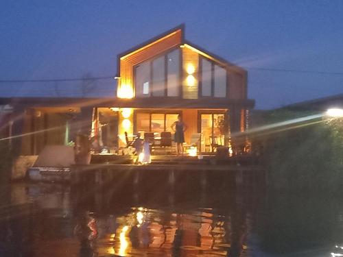 a house with people standing outside of it at night at House ThoNi in Gornji Štoj