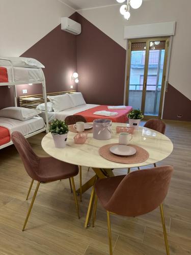 a room with a table and chairs and a bed at B&B Elegance in Villa San Giovanni