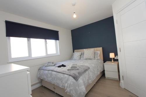 1 dormitorio con cama y pared de acento azul en Central London Apartment Zone 1 en Londres