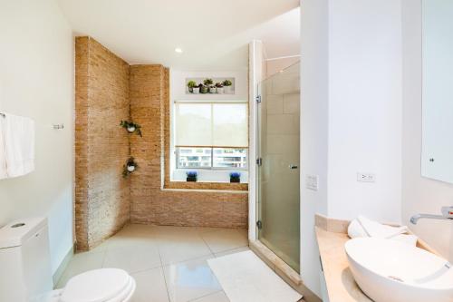 a bathroom with a shower and a toilet and a sink at Sea La Vie Suites - By The Beach in Tamarindo