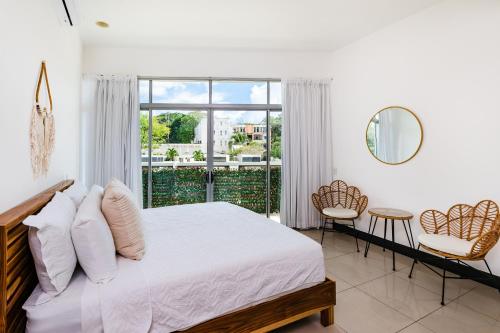 1 dormitorio con cama y ventana grande en Sea La Vie Suites - By The Beach, en Tamarindo