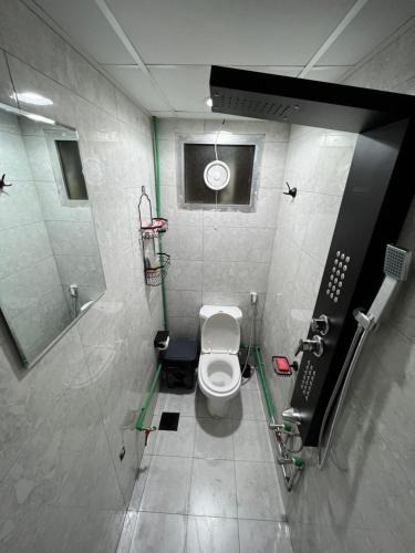 a bathroom with a toilet and a sink and a mirror at Dinar apartments in Abu Dhabi