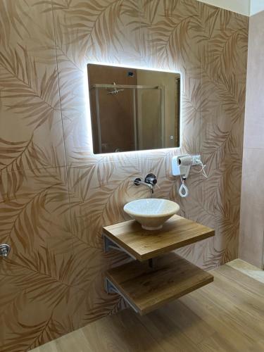 a bathroom with a sink and a mirror on a wall at B&B Elegance in Villa San Giovanni