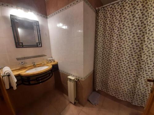 baño con lavabo y cortina de ducha en Cabañas LUGAR SOÑADO en San Martín de los Andes