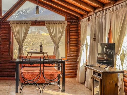 a dining room with a table and a window at Cabañas Aventurados in Potrerillos