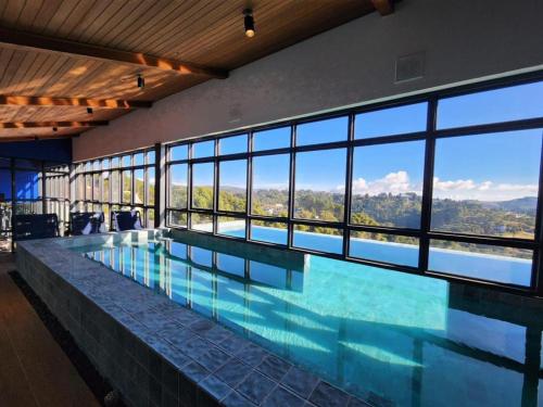 a large swimming pool with a large wall of windows at Quarto no Wanderlust Experience Hotel in Campos do Jordão