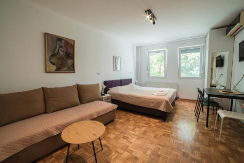 a living room with a couch and a bed at Arena East Apartment in Belgrade