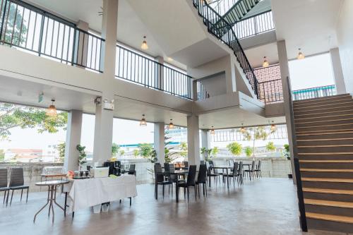 a restaurant with tables and chairs and a staircase at Phu sakon ville hotel in Ban Phang Khwang Tai