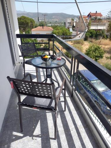 a table and chairs on the balcony of a house at TriΖin in Galatas