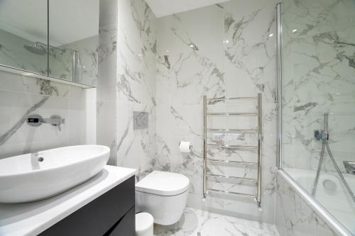 a bathroom with a sink and a toilet and a shower at 3 Bedroom flat with Terrace in Central London in London