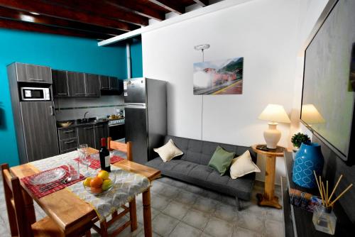 eine Küche und ein Wohnzimmer mit einem Tisch und einem Sofa in der Unterkunft Cálido Destino in Ushuaia