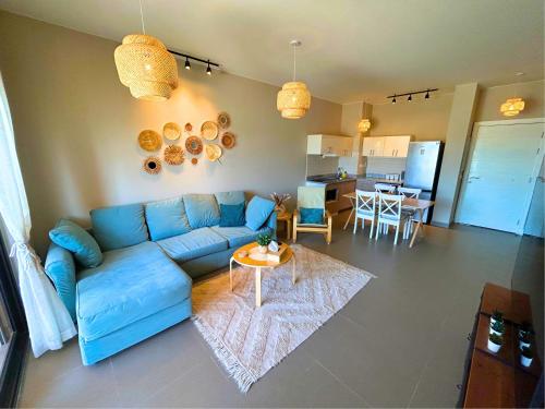 uma sala de estar com um sofá azul e uma mesa em Lily's Place - Scenic Lagoon View at Tawila, Gouna em Hurghada